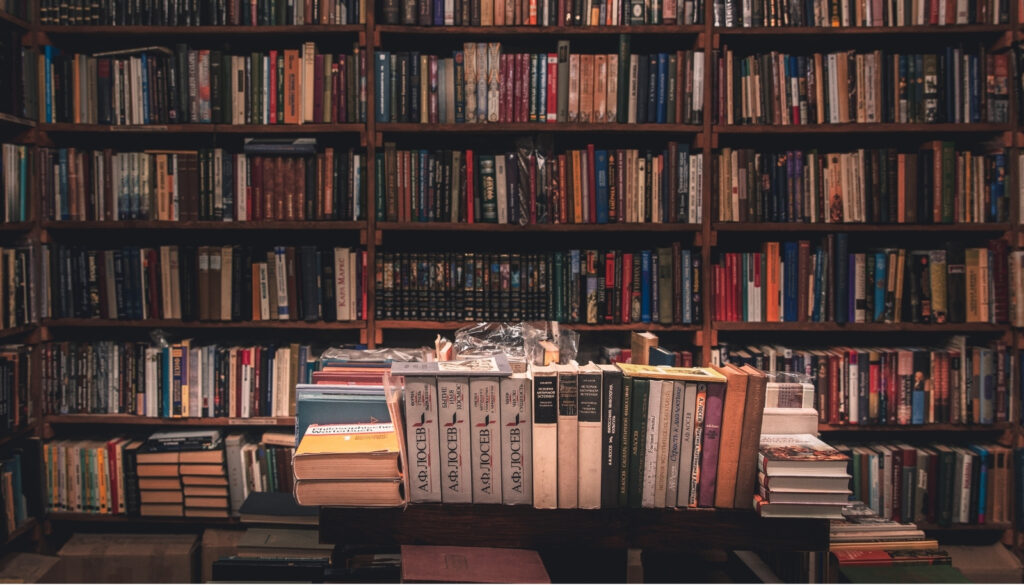 図書館の棚や机に、数え切れないほどの書籍が詰め込まれている様子。大規模言語モデル(LLM)の学習に使われた、膨大なテキストデータを象徴する画像。