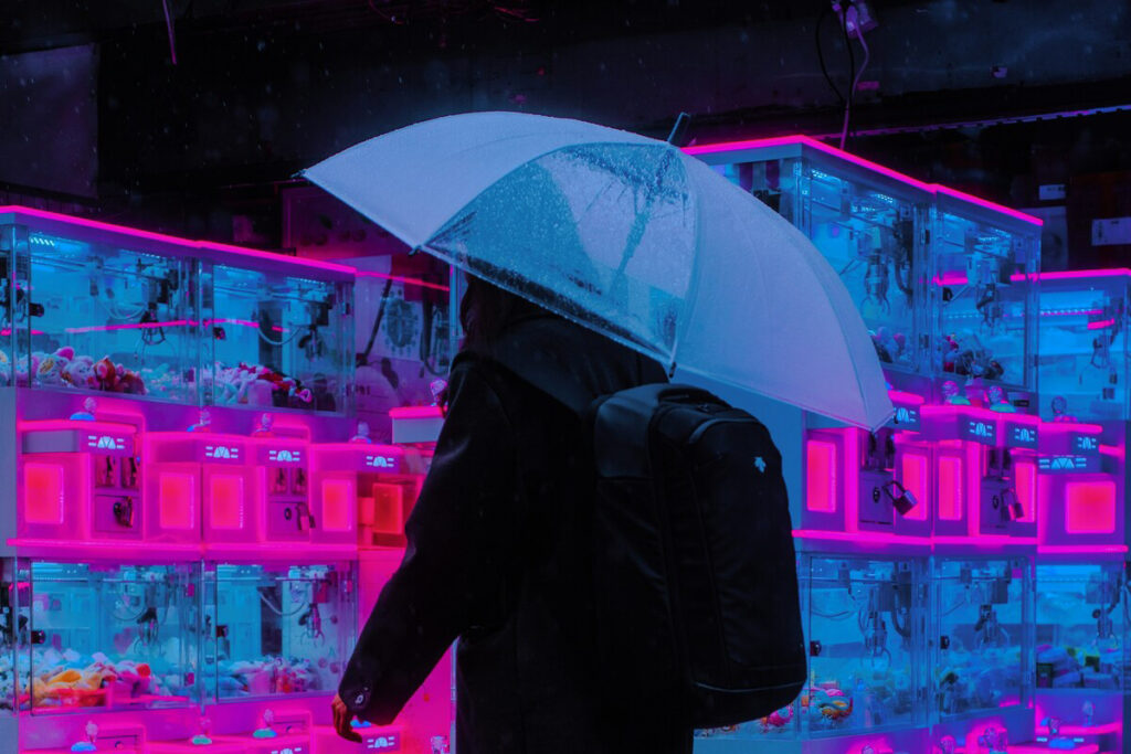 雨の夜、近未来的なネオンの光の中に立つ人物のシルエット